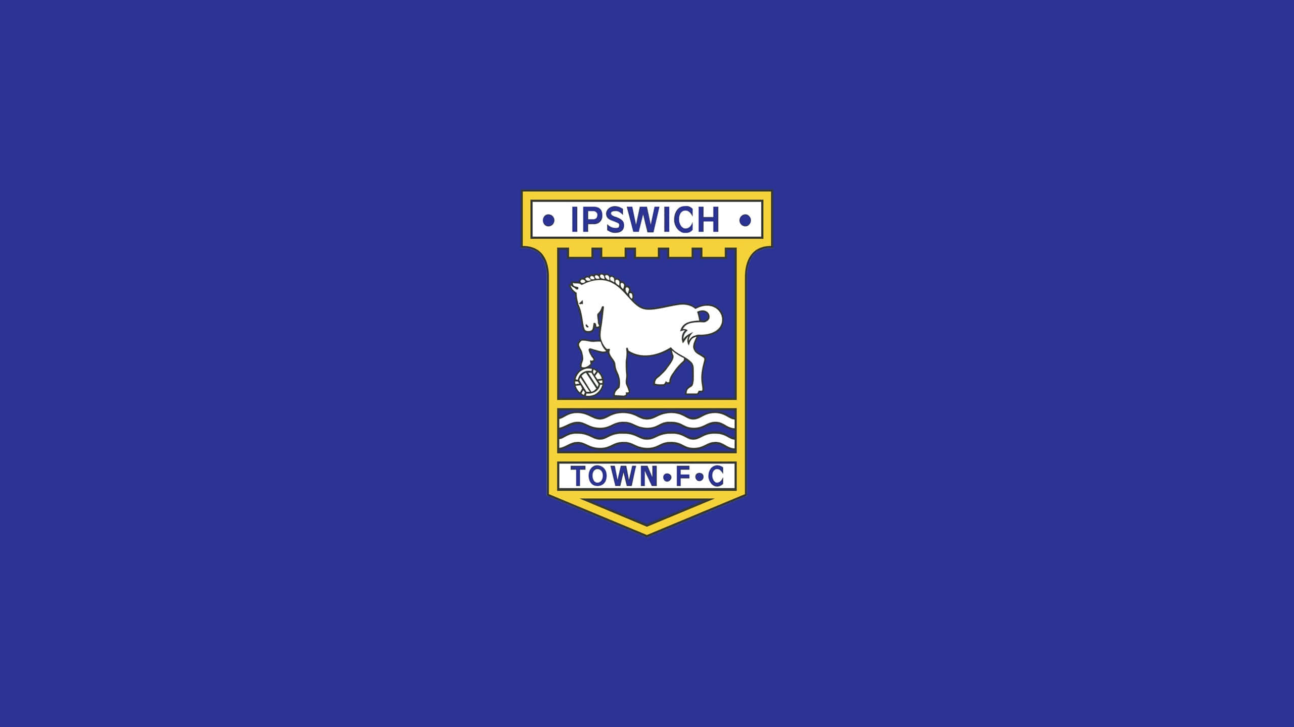Ipswich Town 桌布 壁紙 — 一個白色馬匹標誌配以足球，立於藍色波浪線上，置於黃色盾牌內，背景為皇家藍色。