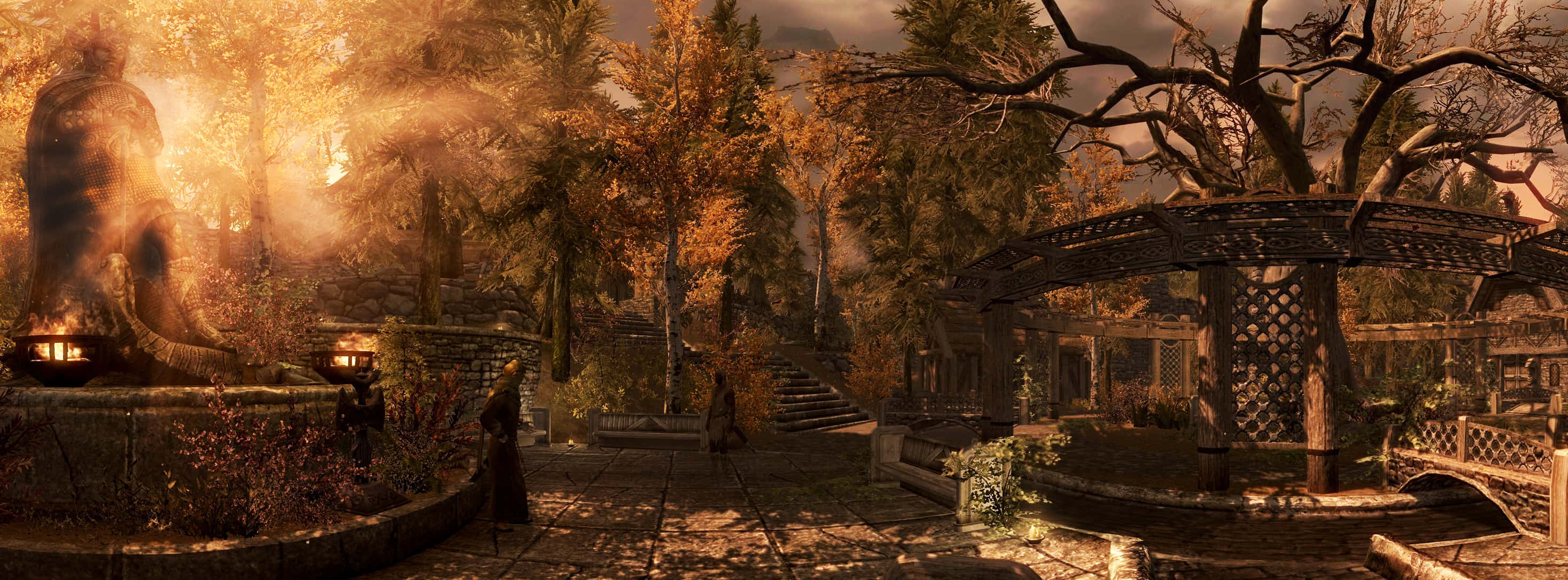 Skyrim Whiterun 桌布 壁紙 — 一個神秘花園沐浴在金色夕陽下，古樹、石徑和發光的噴泉投下溫暖的陰影。