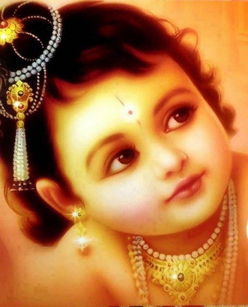 krishna god 桌布 壁紙 — 一個神聖的孩子，深色捲髮，佩戴金色珠寶，在溫暖發光的背景下溫柔地凝視。