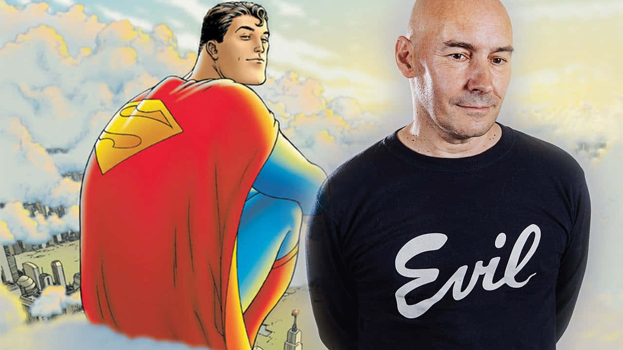Grant Morrison 桌布 壁紙 — 一個穿著「Evil」T恤的男人站在漫畫風格的超人旁邊，俯瞰著陰天天空下的城市景觀。