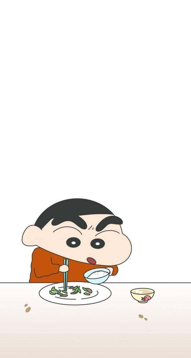 shin chan iPhone 桌布 壁紙 — 一個穿著橙色襯衫的卡通男孩用筷子在散落著食物和一碗飯的桌子上吃飯。