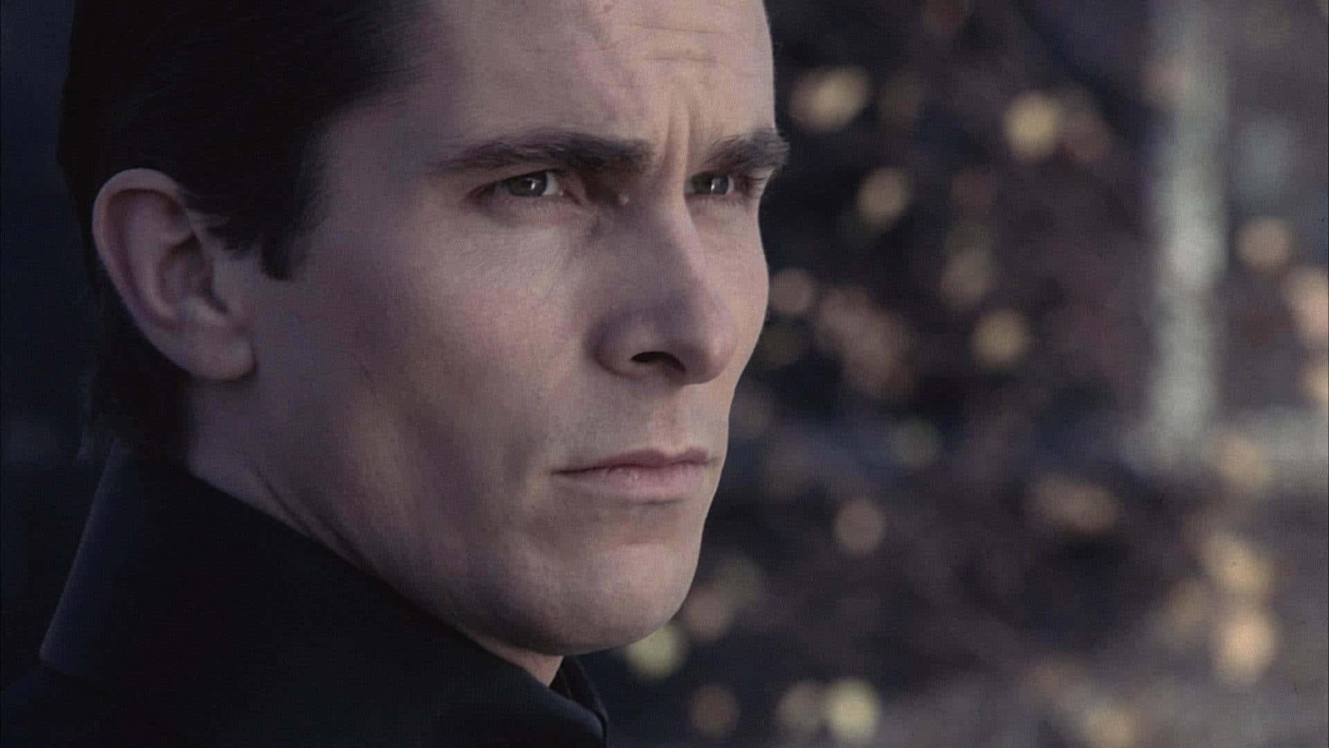 Bruce Wayne 桌布 壁紙 — 一個穿著深色外套的男人，在柔和模糊的秋日背景下若有所思地凝視遠方。