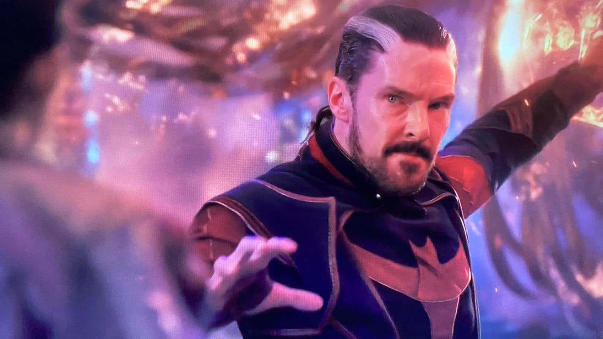 Dr Strange 桌布 壁紙 — 一個穿著深色宇宙服的男人，在旋轉星雲背景下，以強烈的專注力引導發光能量。