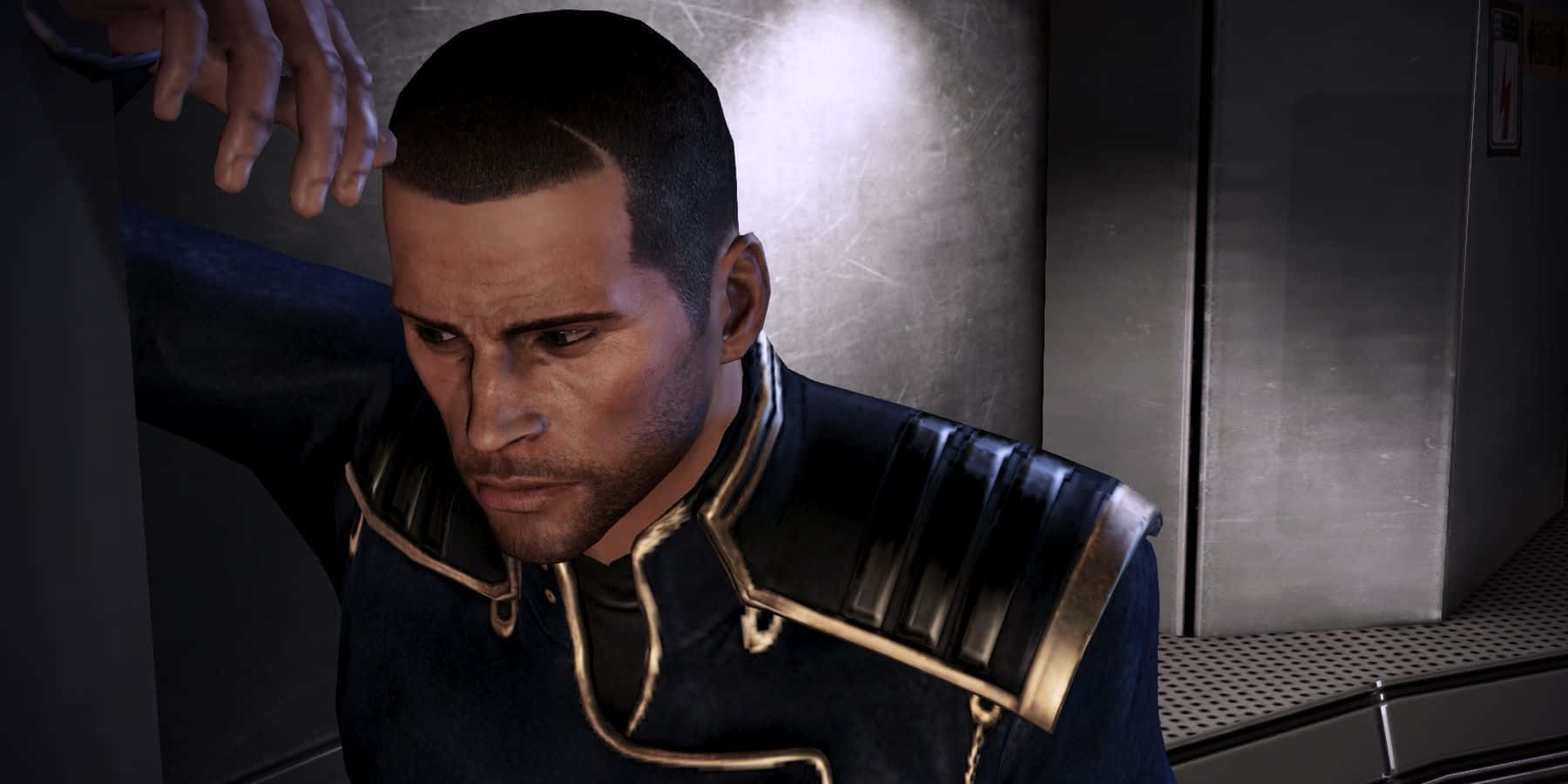 Commander Shepard 桌布 壁紙 — 一個穿著深色金色飾邊制服的男人在昏暗的金屬走廊中低頭看著。
