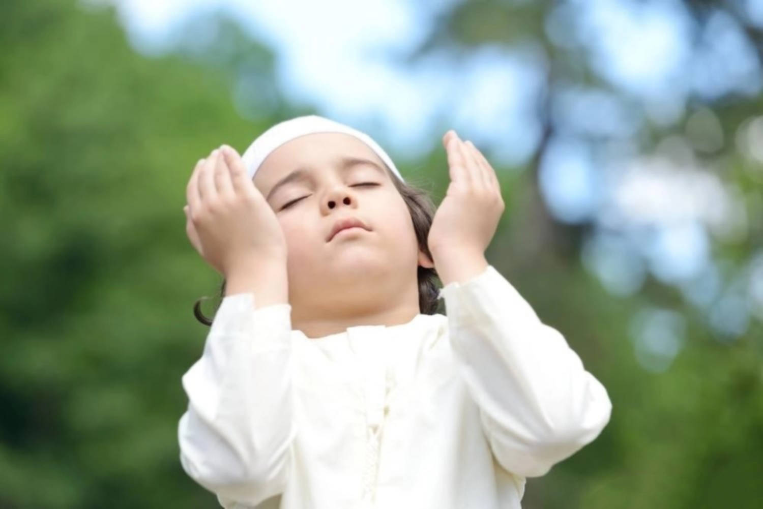 Praying 桌布 壁紙 — 一個穿著白色祈禱服的小孩閉上眼睛，在戶外平靜地舉手祈禱。