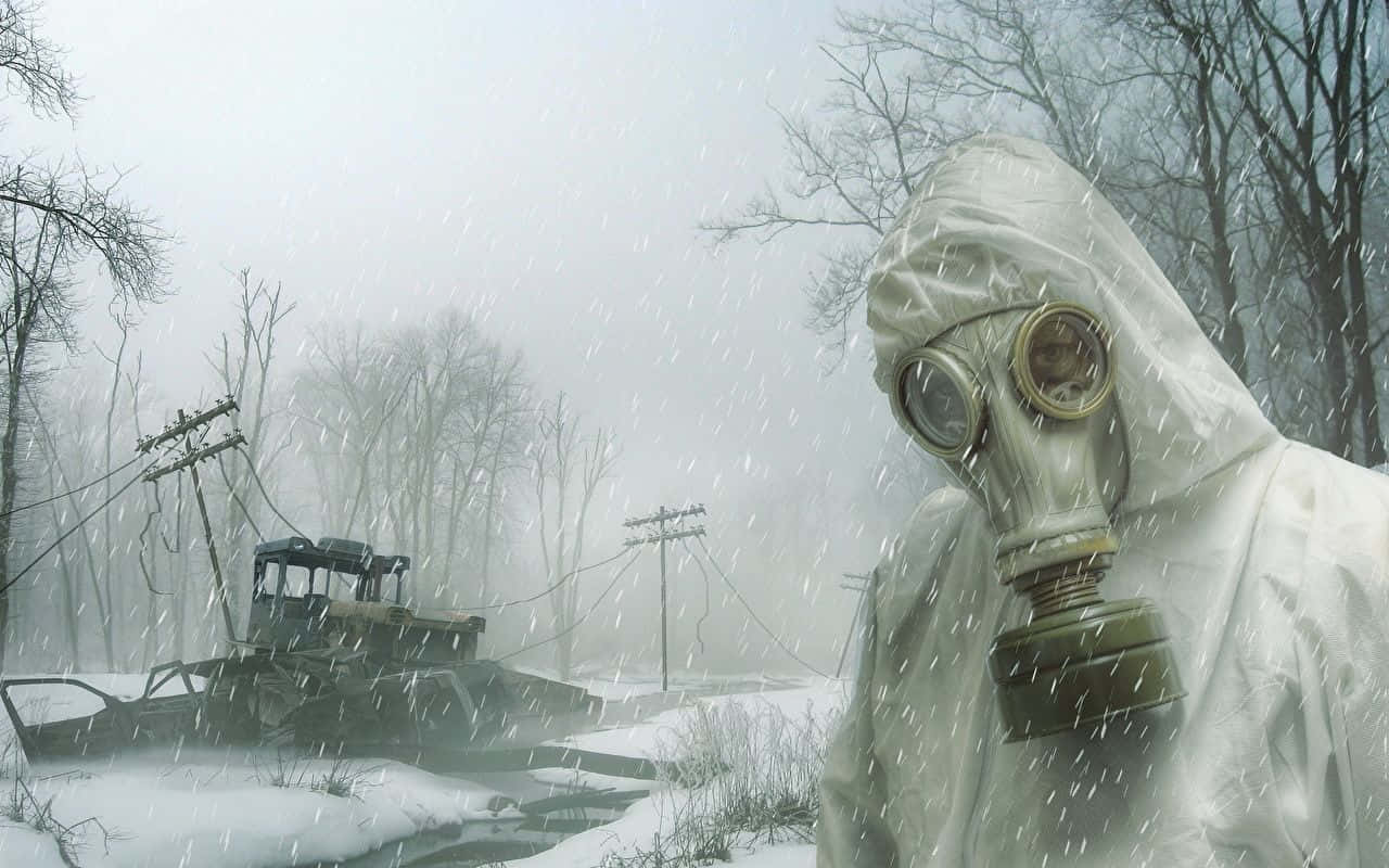 Winter Games 桌布 壁紙 — 一個穿著白色防護衣和防毒面具的人站在積雪、廢棄的冬季景觀中，有一輛破損的車輛和光禿禿的樹木。