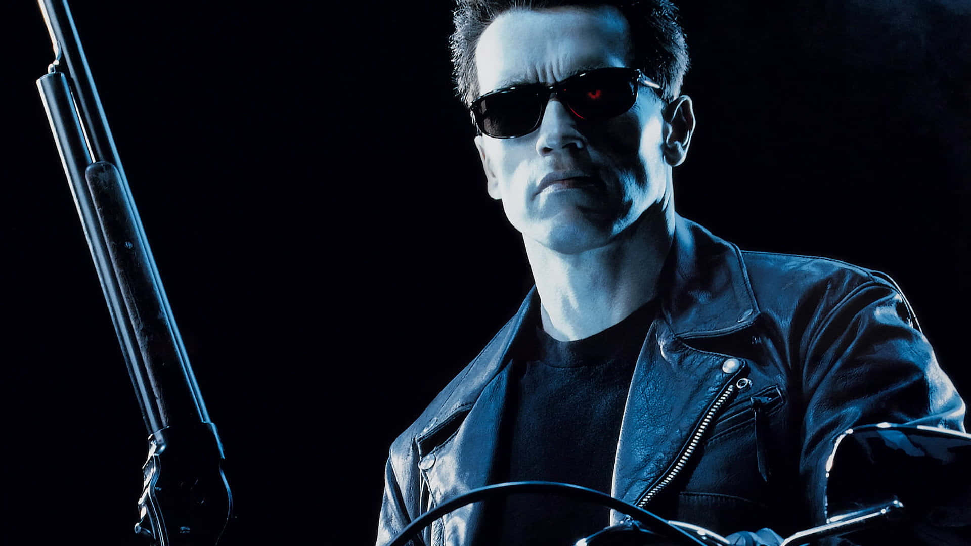 Sunglasses 桌布 壁紙 — 一個穿著皮褸和太陽眼鏡的威脅性半機械人，在黑暗背景下手持霰彈槍，眼睛發出紅光。