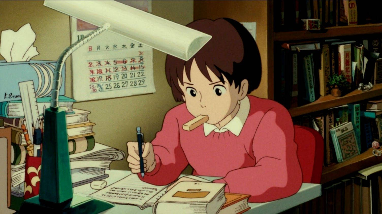 吉卜力 桌布 壁紙 — 一個穿著粉紅色毛衣的女孩在明亮的燈光下，於堆滿書籍的凌亂書桌上專心學習。