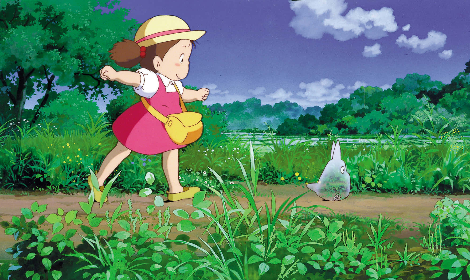 my neighbor totoro 桌布 壁紙 — 一個穿著粉紅色連衣裙和黃色帽子的年輕女孩，在紫色天空和蓬鬆雲朵下，穿過茂密的綠色田野跑向一隻灰色的兔子。