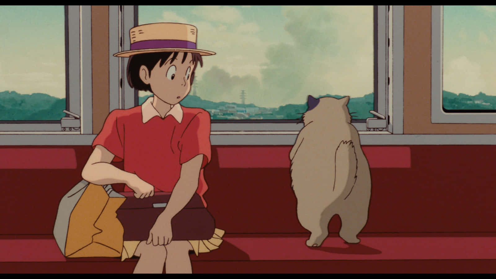 Whisper Of The Heart 桌布 壁紙 — 一個穿著紅色襯衫和草帽的小女孩坐在火車上，旁邊有一隻毛茸茸的貓，一起凝視著多雲天空下的綠色山丘。