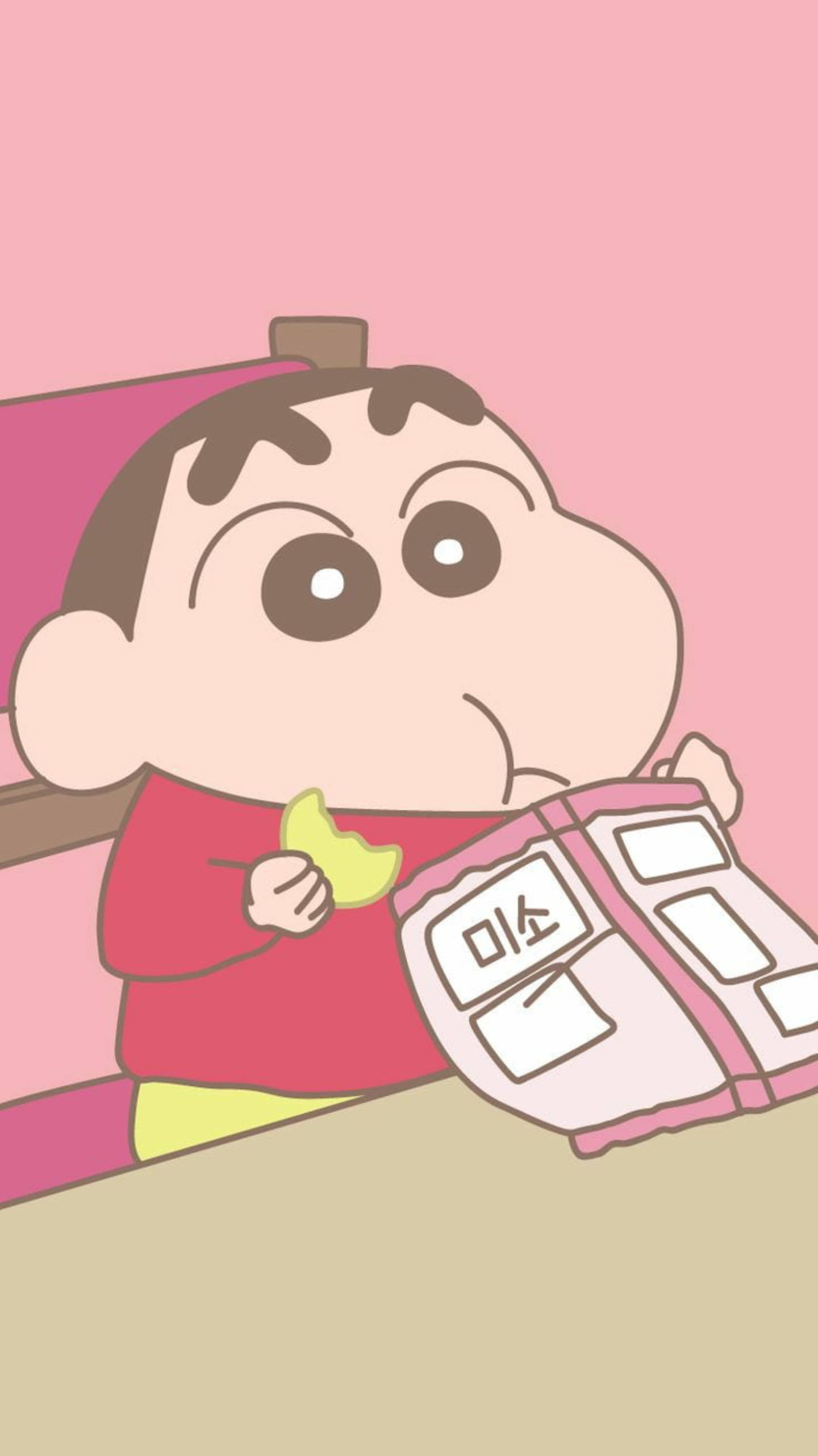 shinchan 桌布 壁紙 — 一個穿著紅色襯衫的卡通男孩在柔和的粉紅色背景下，一邊拿著粉紅色零食包裝，一邊吃香蕉。