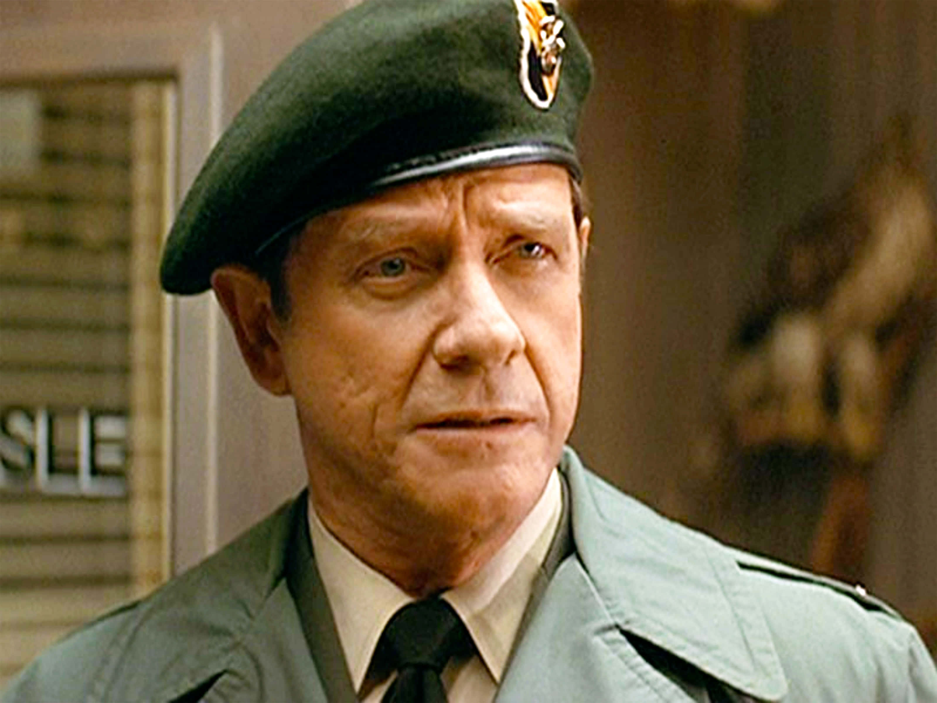 Richard Crenna 桌布 壁紙 — 一個穿著綠色軍裝和貝雷帽的嚴肅男子，帶著認真的表情凝視著。