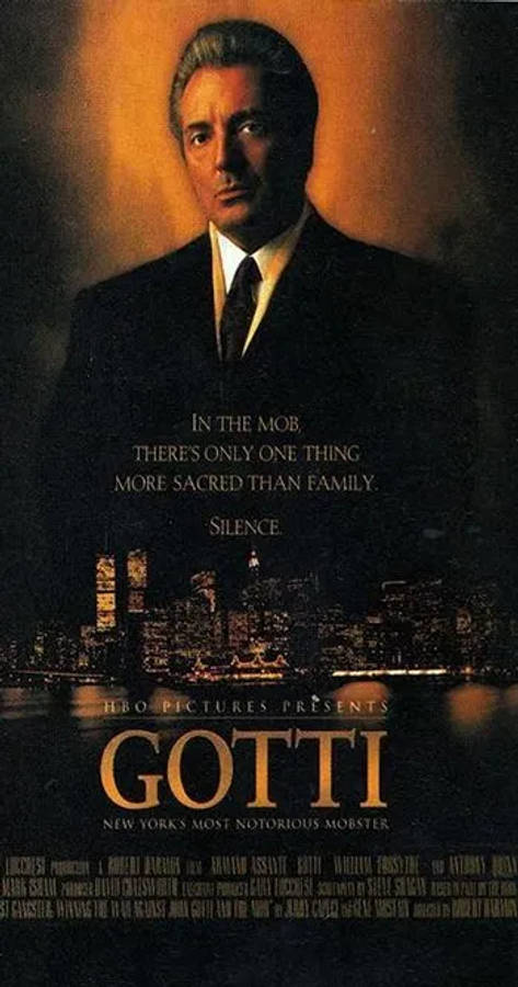 Gotti 桌布 壁紙 — 一個穿著西裝的男人在發光的橙色背景和下方城市天際線下的戲劇性肖像。