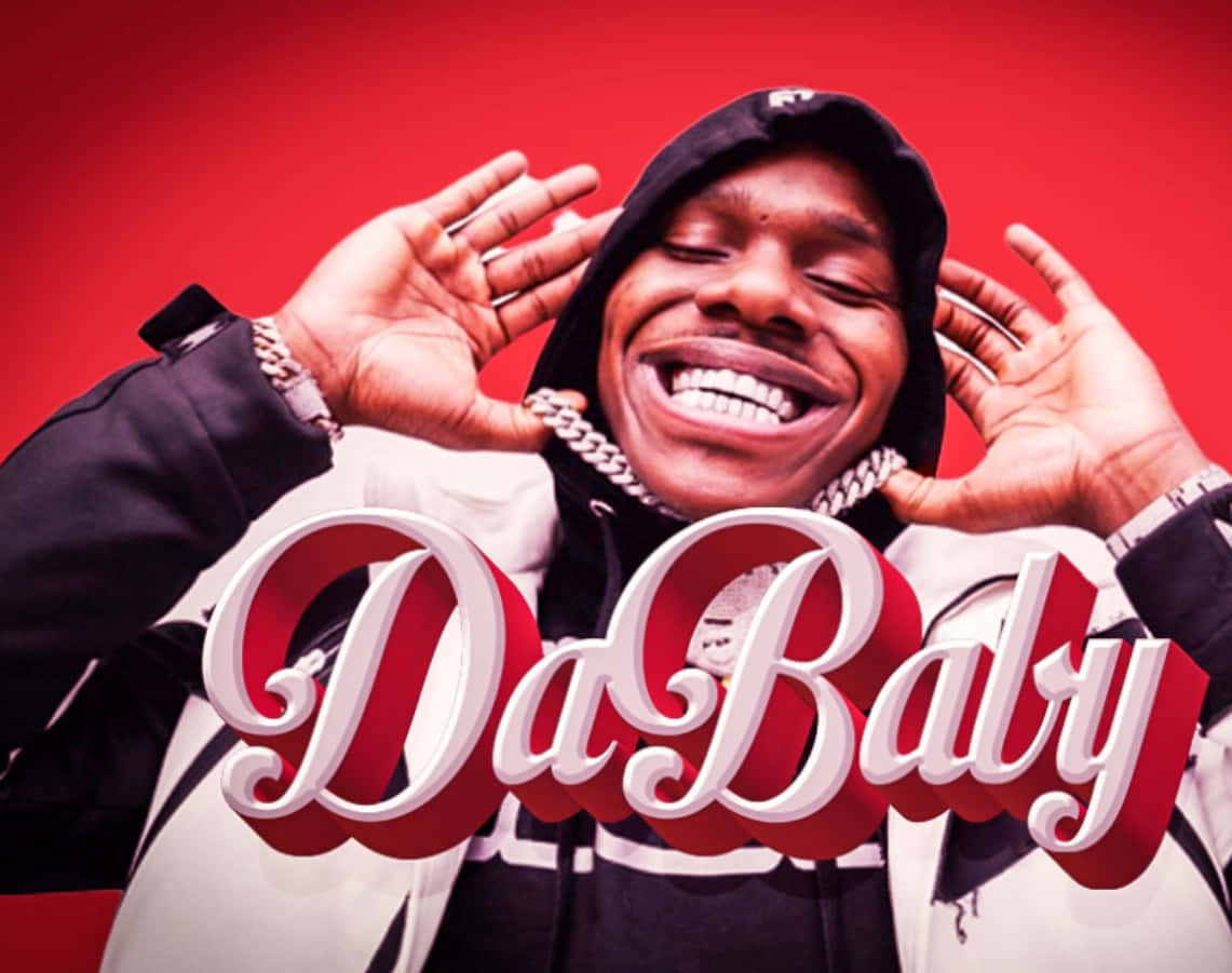 Dababy 桌布 壁紙 — 一個穿著連帽衫的快樂男人在鮮紅色背景前高舉雙手大笑。