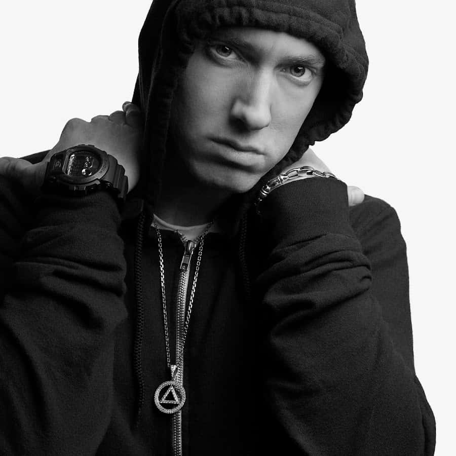 Eminem 桌布 壁紙 — 一個穿著連帽衫的男人，雙手放在肩膀上，戴著手錶和鏈條，眼神銳利的黑白肖像。