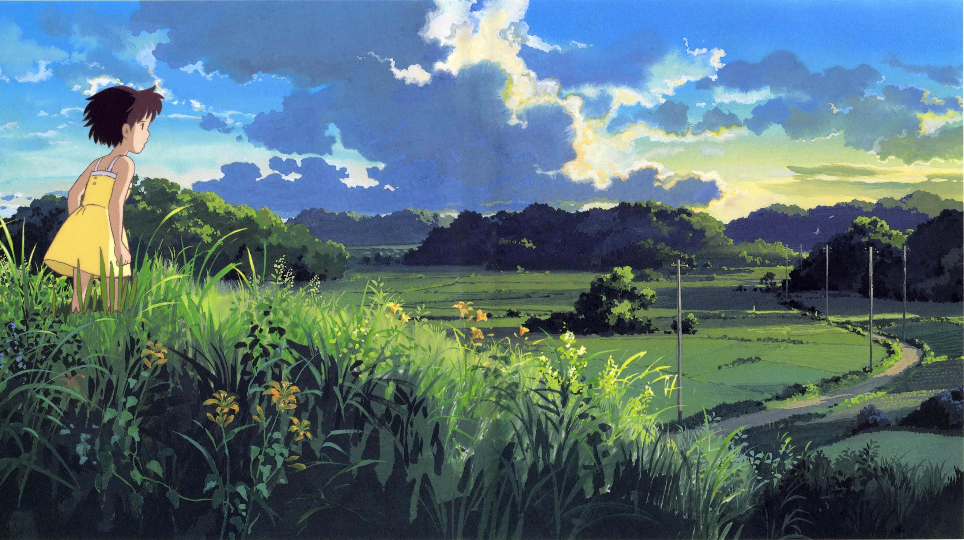 my neighbor totoro 桌布 壁紙 — 一個穿著黃色連衣裙的小女孩站在長滿草的山丘上，俯瞰著陽光明媚的山谷，山谷中有蜿蜒的小徑和遠處的樹木，天空壯麗。