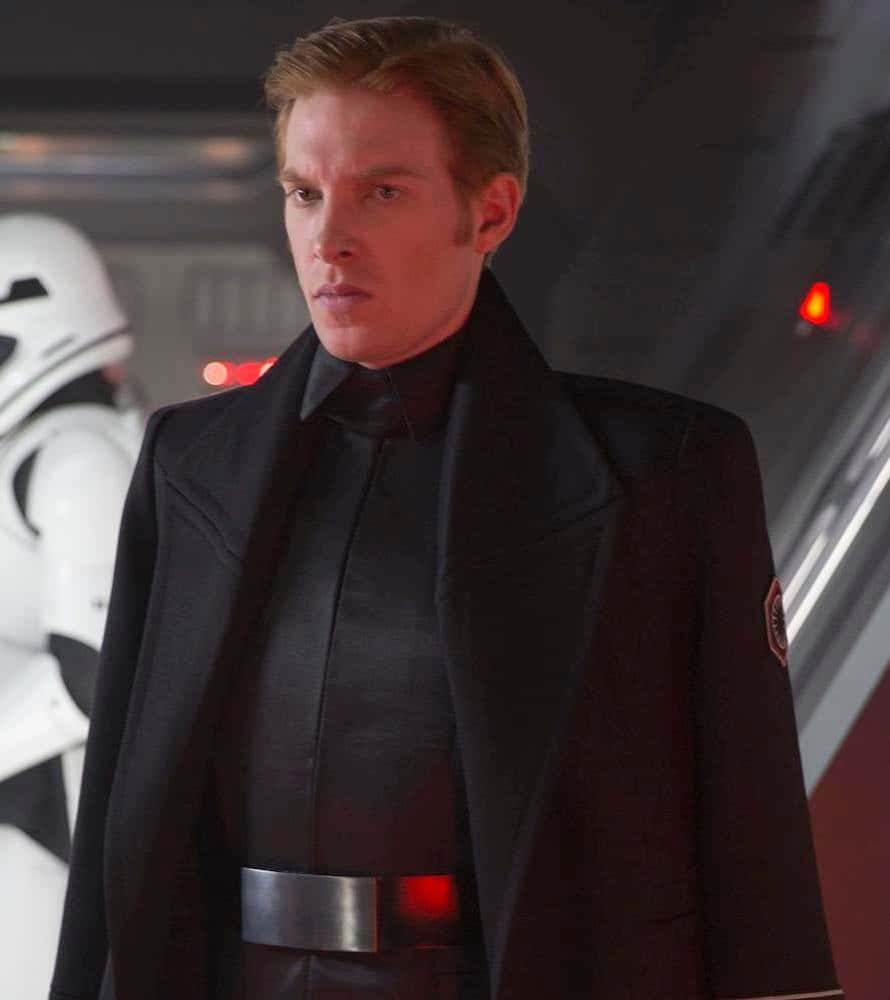 The First Order 桌布 壁紙 — 一個穿著黑色帝國制服、表情嚴肅的男人站在太空船走廊，身後有一名風暴兵。