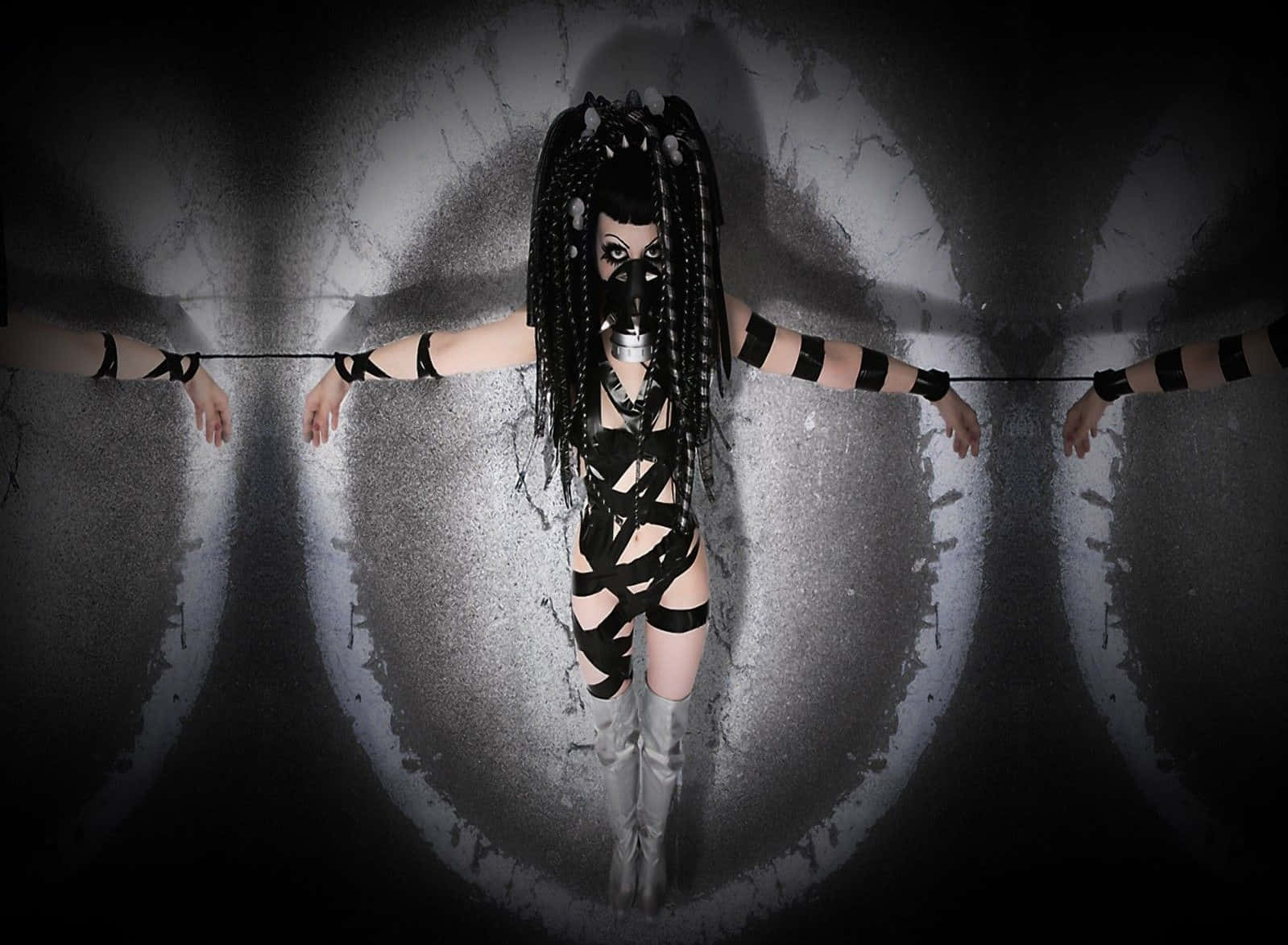 Dark Gothic 桌布 壁紙 — 一個穿著黑色束縛裝備和面具的人站在黑暗隧道中央，雙臂伸展開來靠著破裂的混凝土牆。