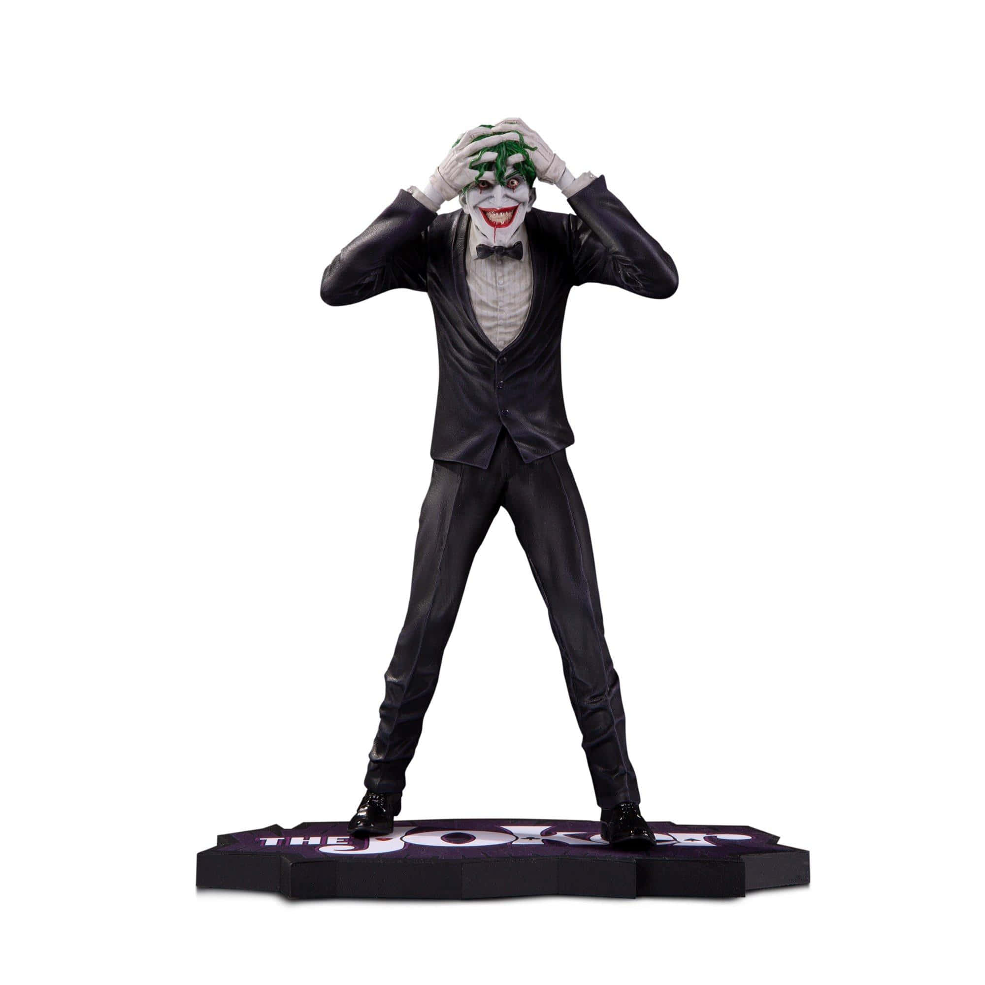 The Killing Joke 桌布 壁紙 — 一個穿著黑色西裝、帶有威脅性的小丑人偶，在純白色背景前用雙手抓著自己的綠色頭髮。