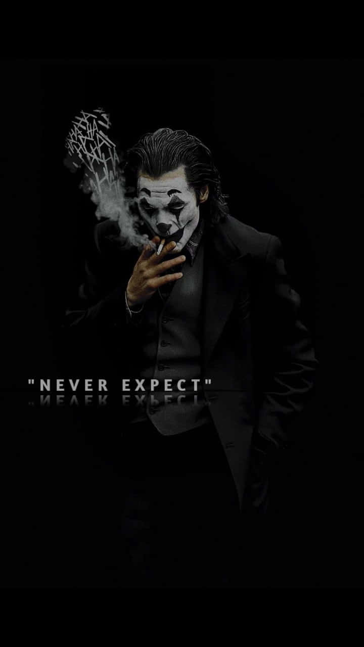 Joker Quotes 桌布 壁紙 — 一個穿著黑色西裝的危險小丑在黑暗背景中抽煙，煙霧形成混亂的文字。
