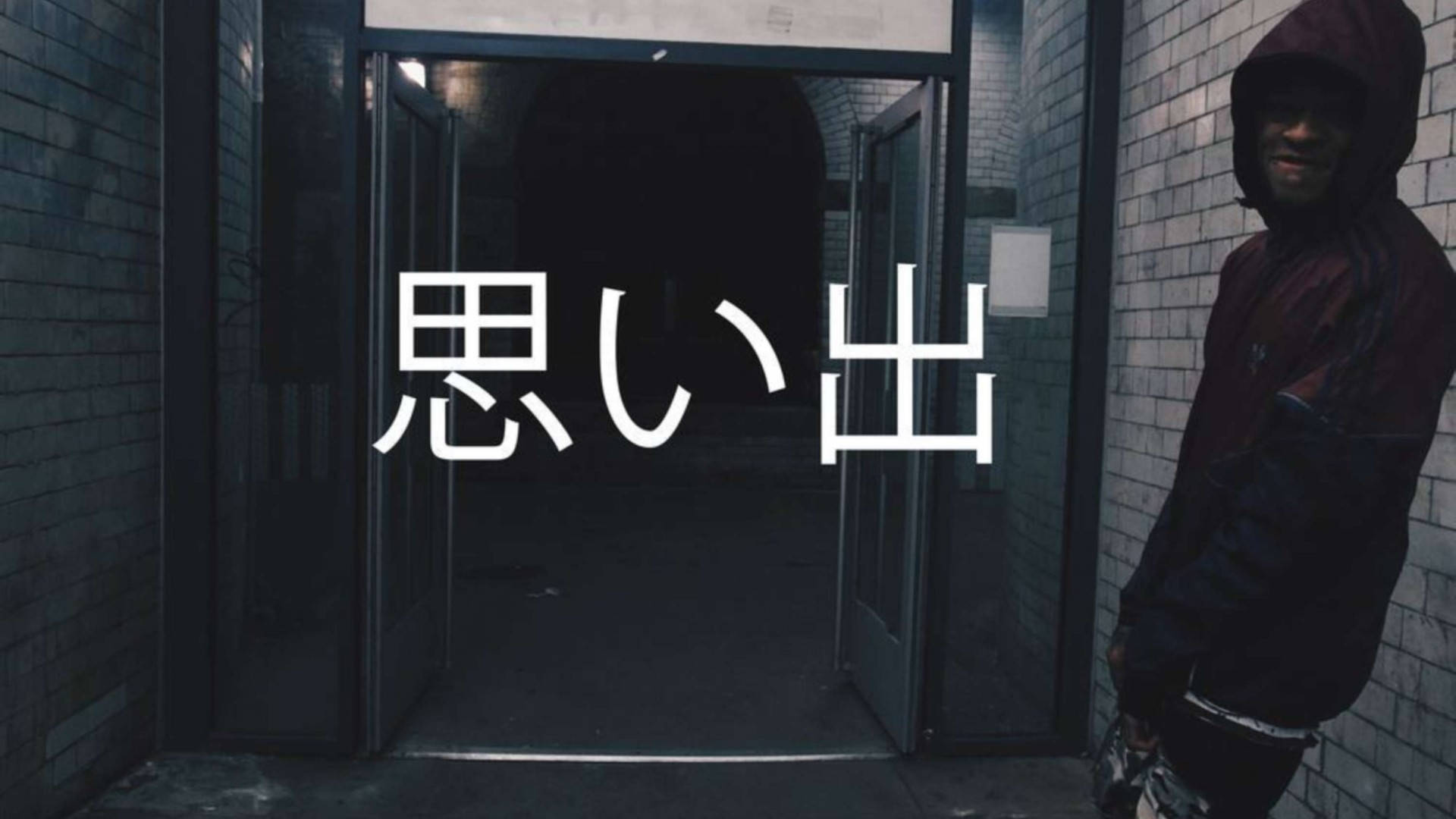 Scarlxrd Omoide 壁紙 — 一個穿連帽衫的人靠著磚牆，旁邊是敞開的門口，上面覆蓋著大型白色日文字元。