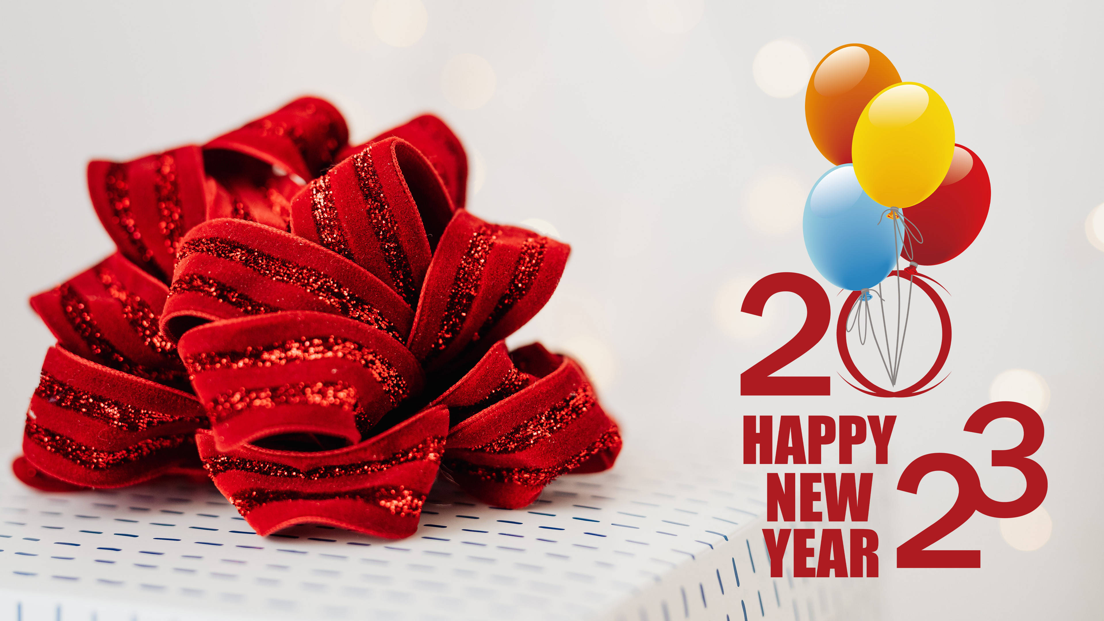 紅色閃粉蝴蝶結和氣球，帶有2023新年文字，在白色表面上。 — 新年快樂 GIF 壁紙