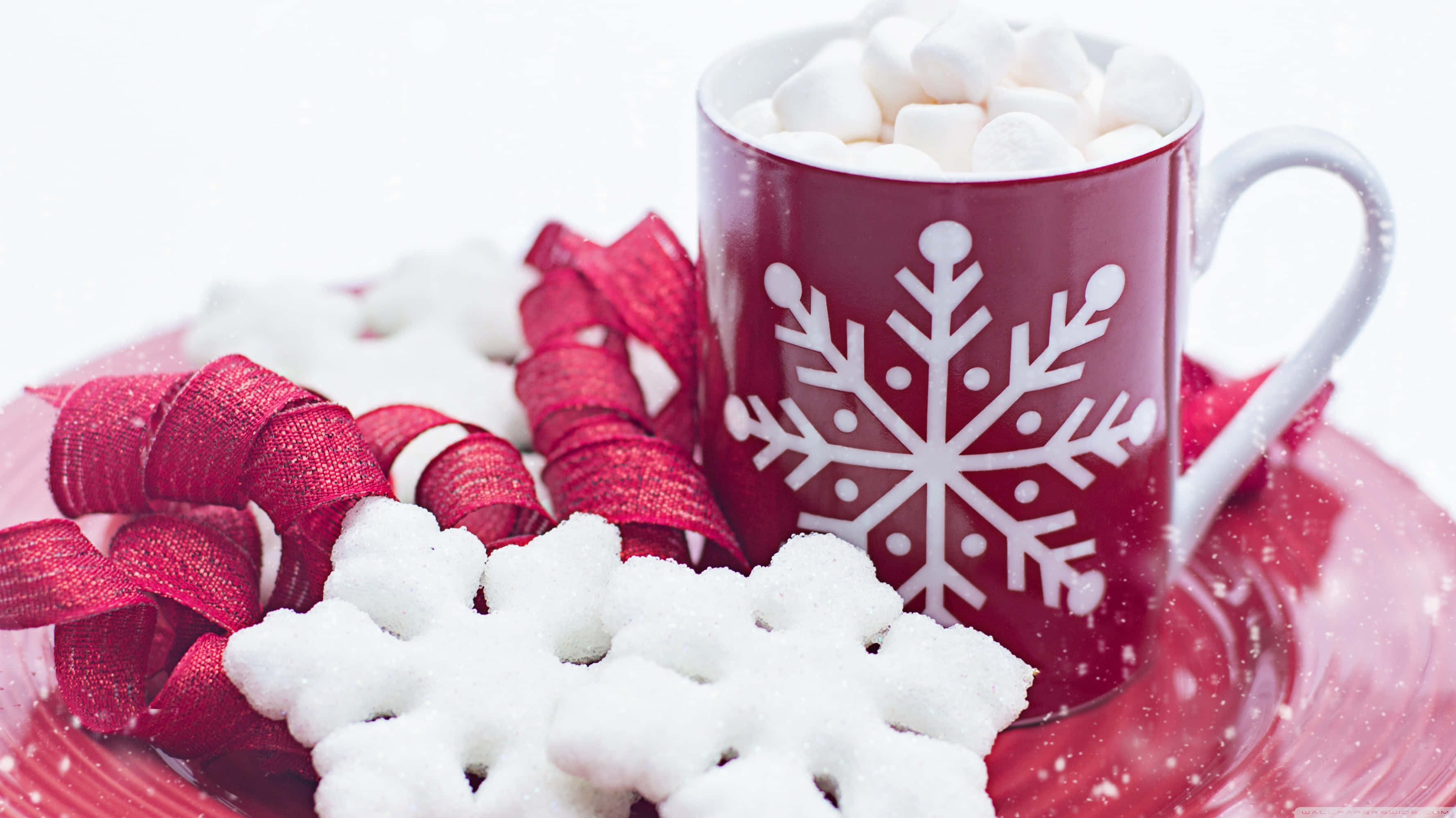 Hot Chocolate 桌布 壁紙 — 一個節日紅色馬克杯裝滿熱可可和棉花糖，旁邊放著雪花曲奇和紅色絲帶，放在相配的碟子上。