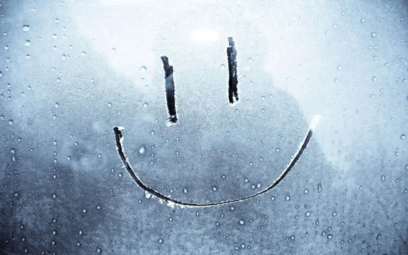 happiness 桌布 壁紙 — 一個簡單的笑臉畫在帶有雨點的窗戶上，背景是柔和的藍灰色。