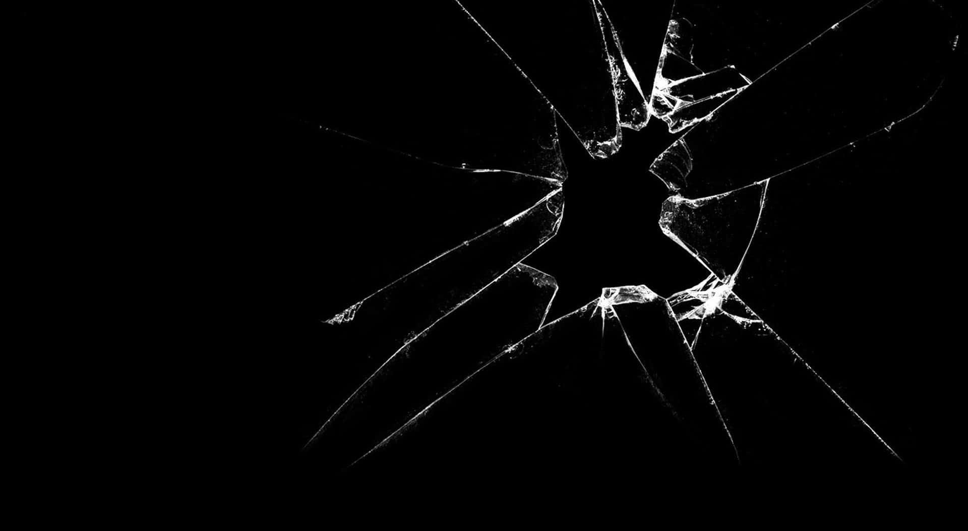 cracked 桌布 壁紙 — 一個簡潔的黑色背景，中央有裂開的玻璃圖案，散發出尖銳的白色裂紋。