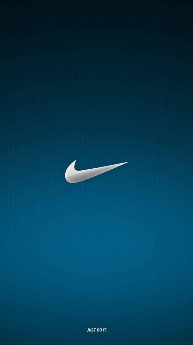 Metallic Nike iPhone Logo 壁紙 — 一個簡約的白色Nike swoosh標誌居中在漸變藍色紋理背景上，底部有標語just do it。