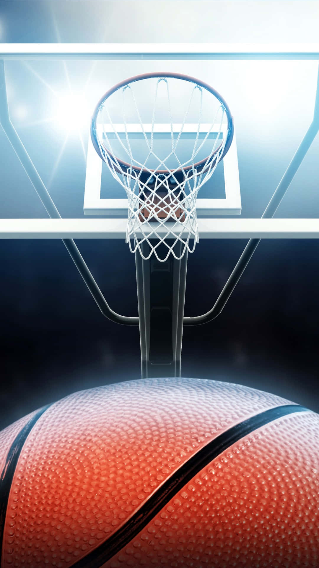 Cool Basketball 桌布 壁紙 — 一個籃球懸浮在籃框下方，明亮的體育場燈光從上方照射。