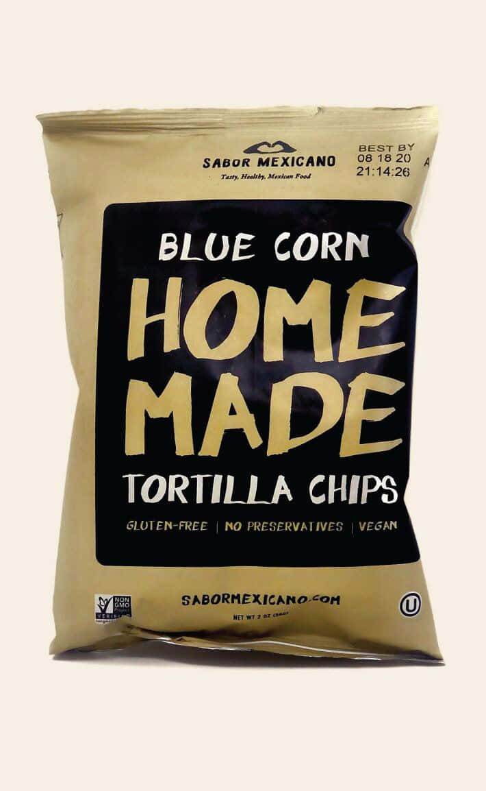 Blue Chips 桌布 壁紙 — 一個米色袋裝有藍粟米自製墨西哥玉米片，帶有粗體金色字體和純素無麩質標籤。