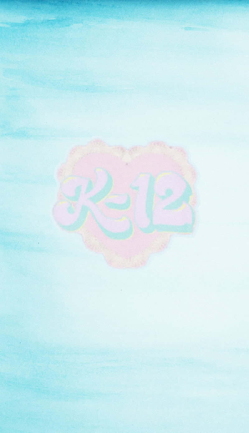 Melanie Martinez 桌布 壁紙 — 一個粉彩水彩心形，帶有 'K-12' 文字，漂浮在柔和漸變的天空背景上。