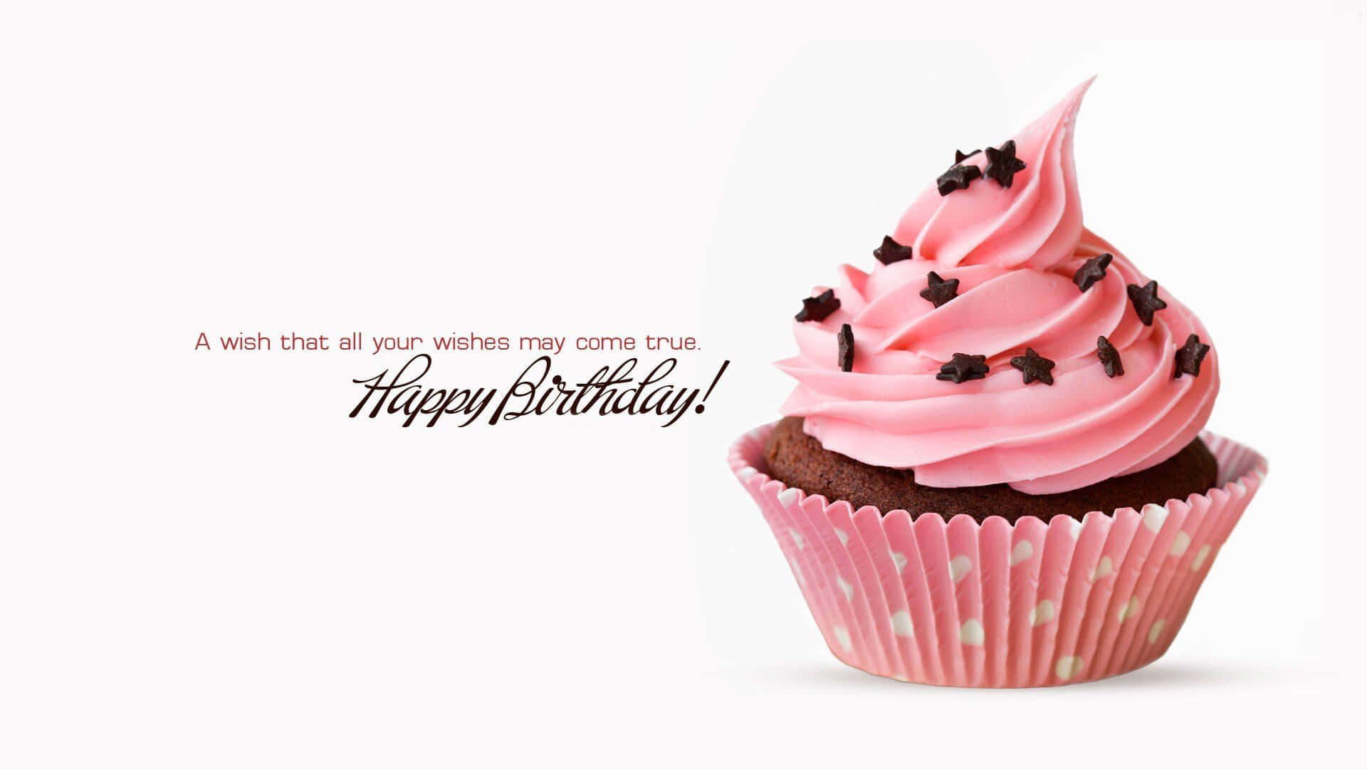 Birthday Wishes 桌布 壁紙 — 一個粉紅色糖霜紙杯蛋糕，上面有朱古力星星裝飾，旁邊放著生日祝福語，背景是潔淨的白色。