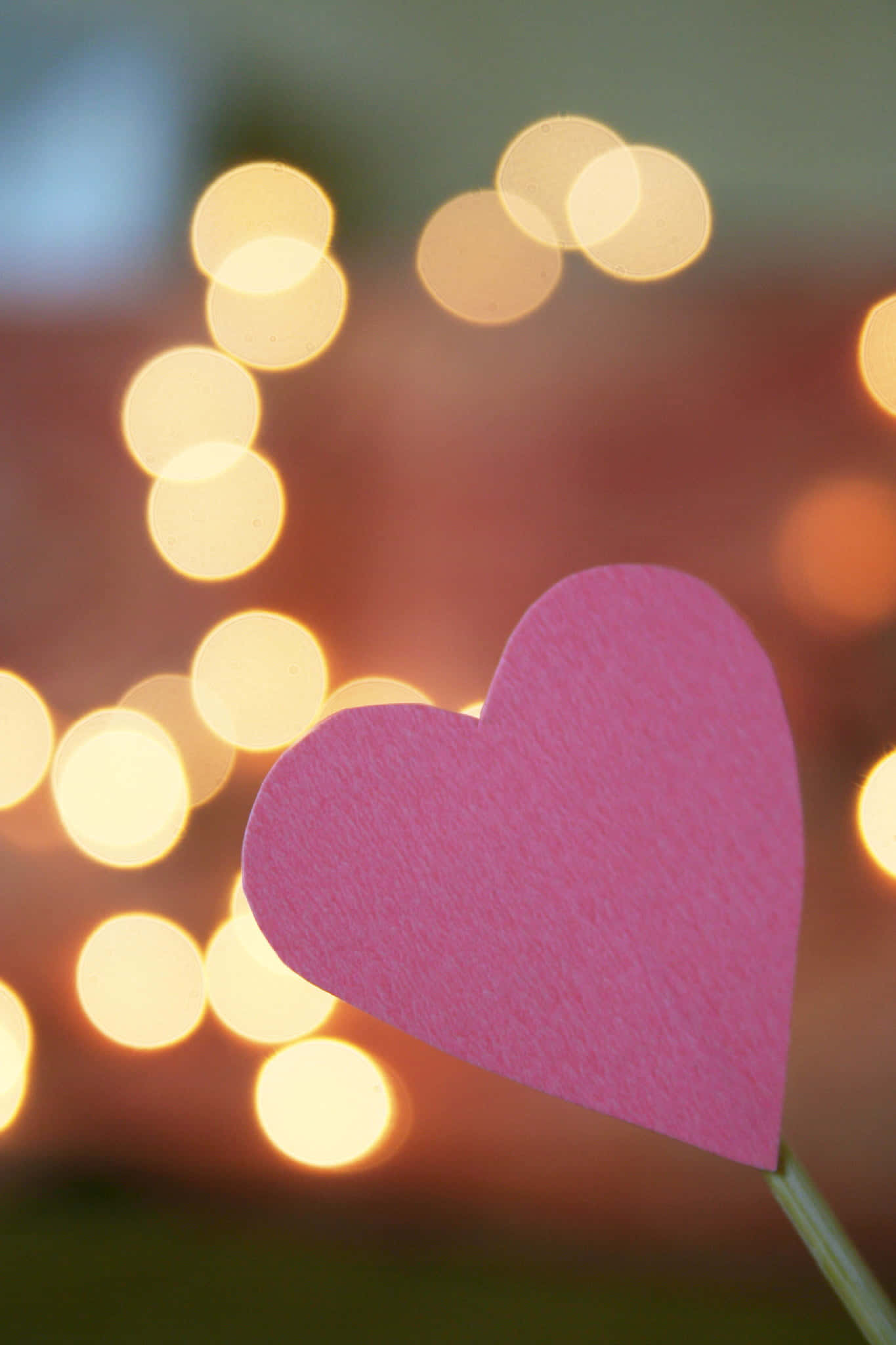 Heart Shape 桌布 壁紙 — 一個粉紅色紙心心在溫暖散景背景中，閃爍的燈串下清晰對焦。