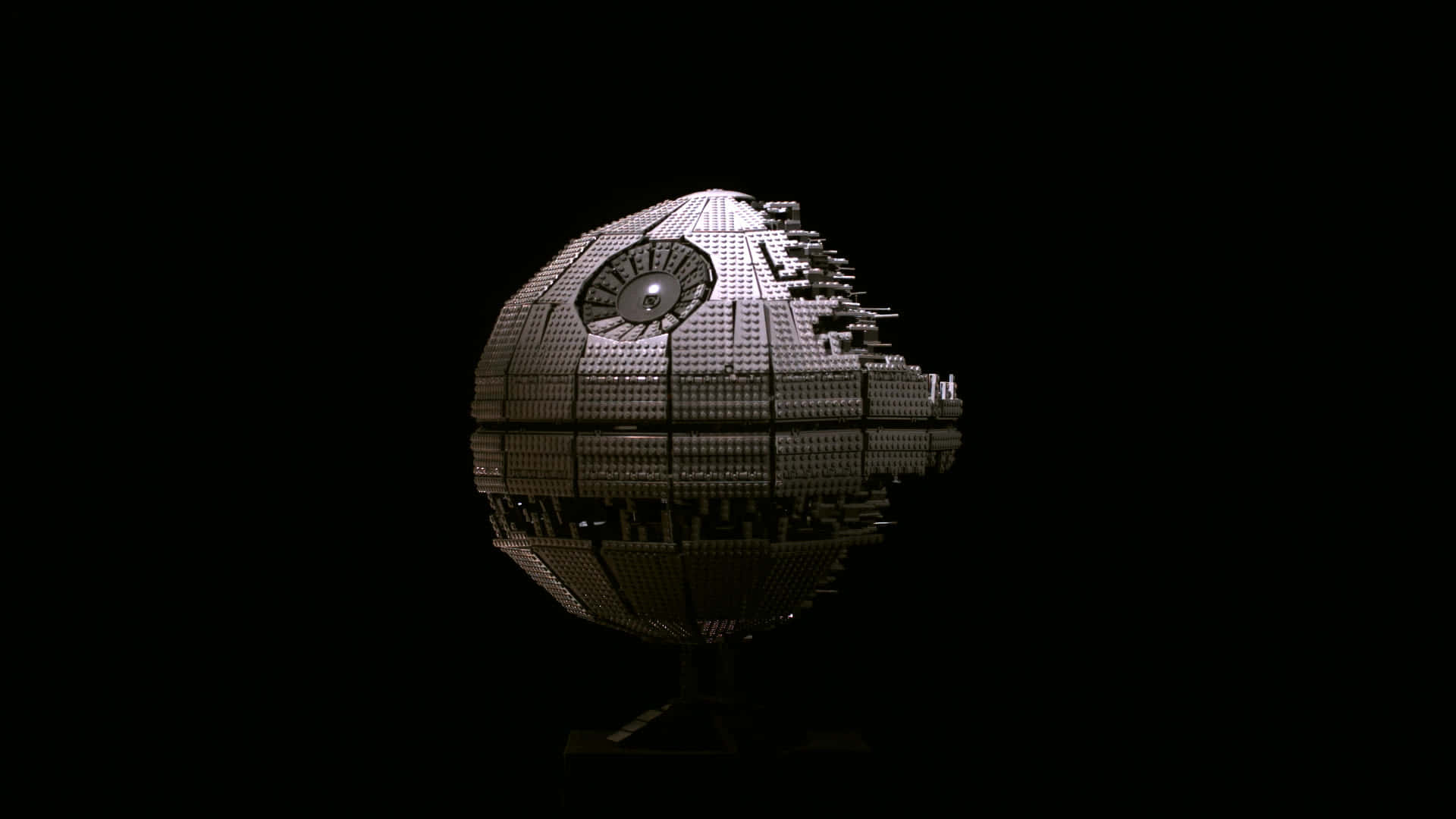 Death Star Ii 桌布 壁紙 — 一個精細的LEGO死星模型，在黑色背景上照亮，下方有反射表面。