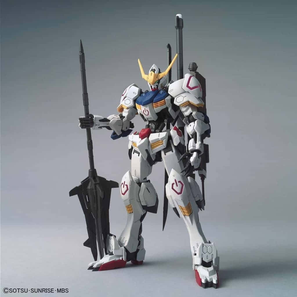 Mobile Suit Gundam Iron-blooded Orphans 桌布 壁紙 — 一個精細的白色、藍色和金色高達模型，手持一把巨大的黑色長矛，站在樸素的灰色工作室背景前。