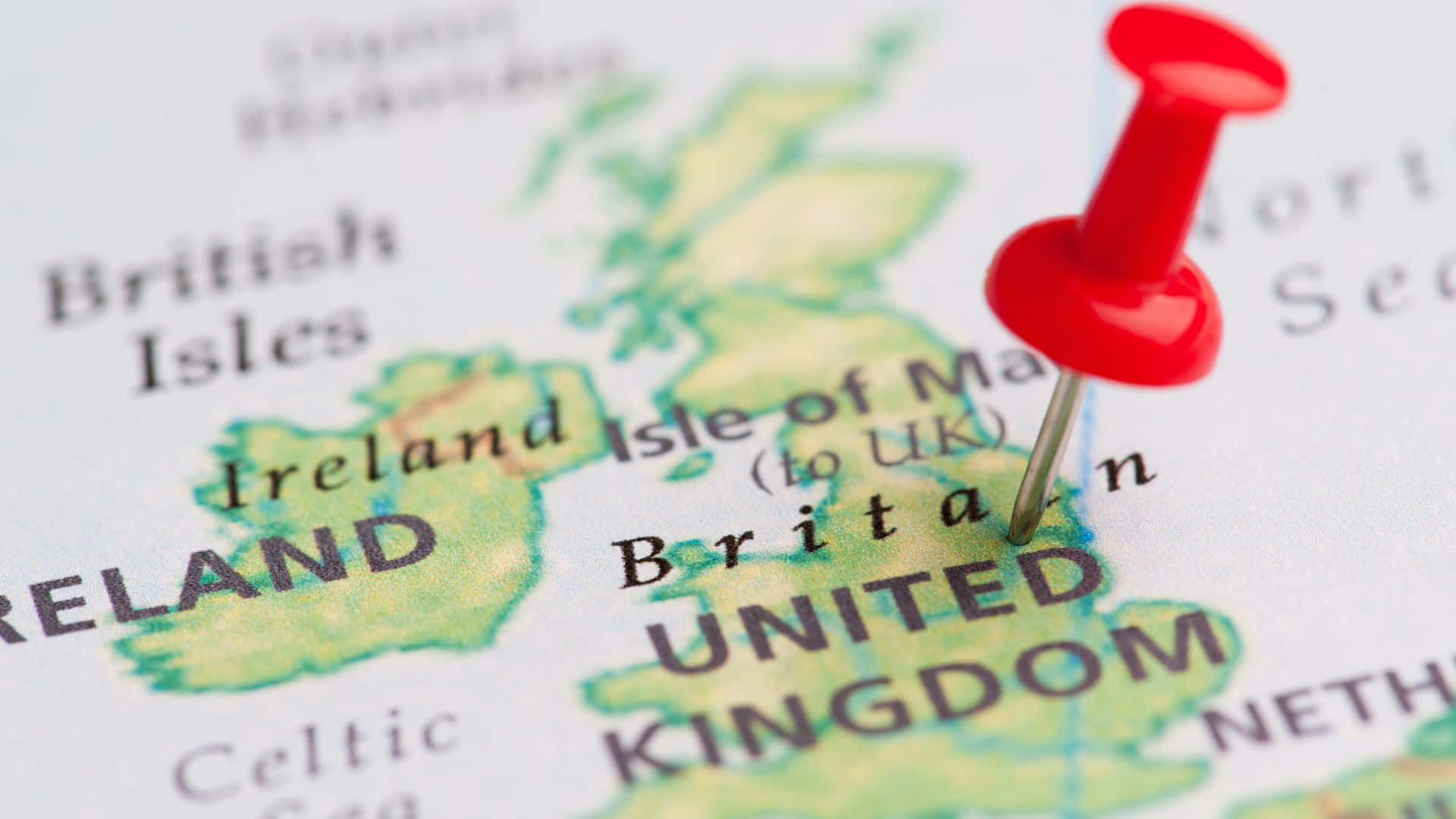 UK 桌布 壁紙 — 一個紅色大頭針在詳細地圖上標記英國，突出顯示愛爾蘭及周邊地區。