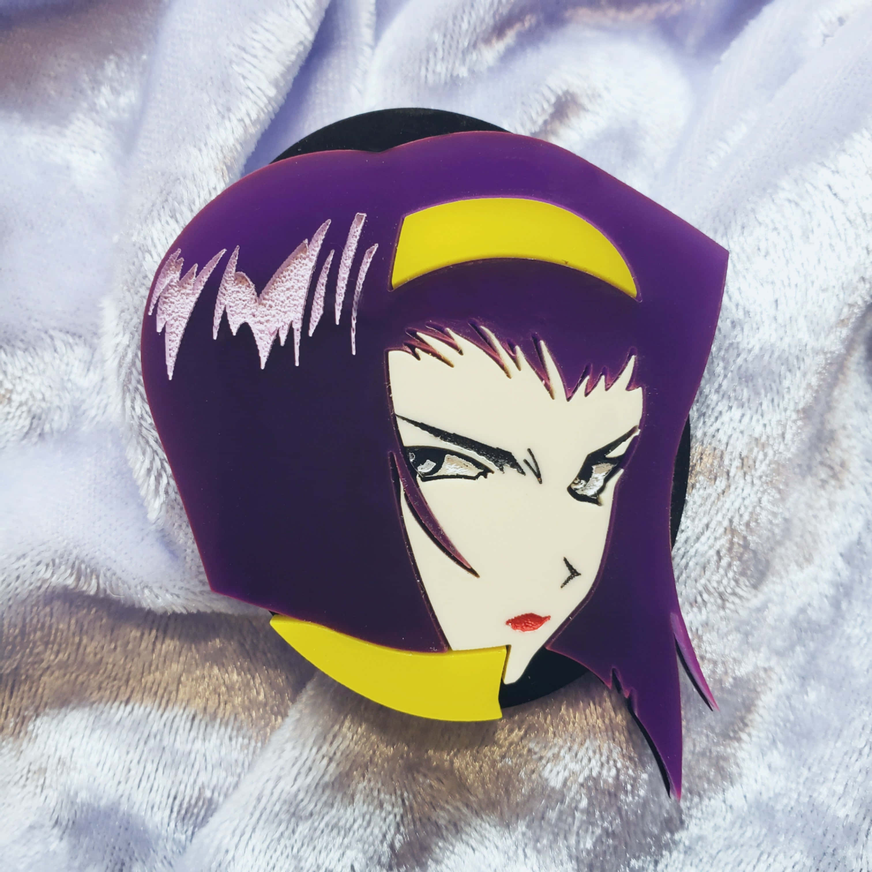 Faye Valentine 桌布 壁紙 — 一個紫色頭髮的動漫角色徽章，帶有黃色點綴，放在一張蓬鬆的白色毯子上。