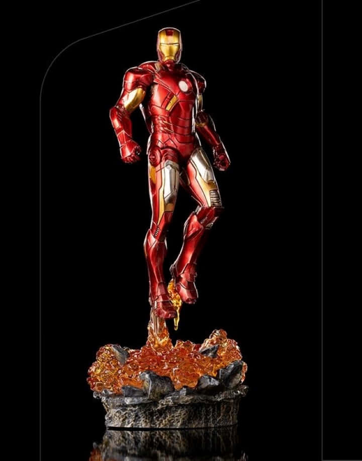 Iron Man Action Figures 桌布 壁紙 — 一個細節豐富的鐵甲奇俠雕像，身穿紅色和金色盔甲，動態地站在岩石底座上，帶有發光的橙色能量效果，背景為黑色。