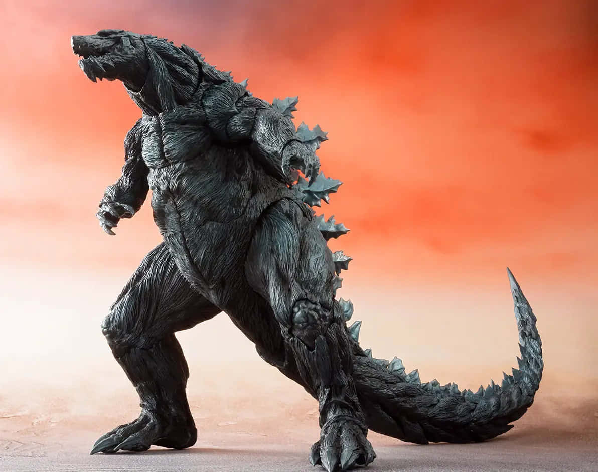 Godzilla Earth 桌布 壁紙 — 一個細節豐富的黑色哥斯拉模型以咆哮姿勢站立，背景是火熱的橙色漸變天空。