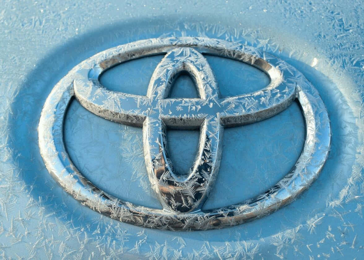 Toyota 桌布 壁紙 — 一個結霜的豐田標誌在冬日陽光下於藍色引擎蓋上閃爍。