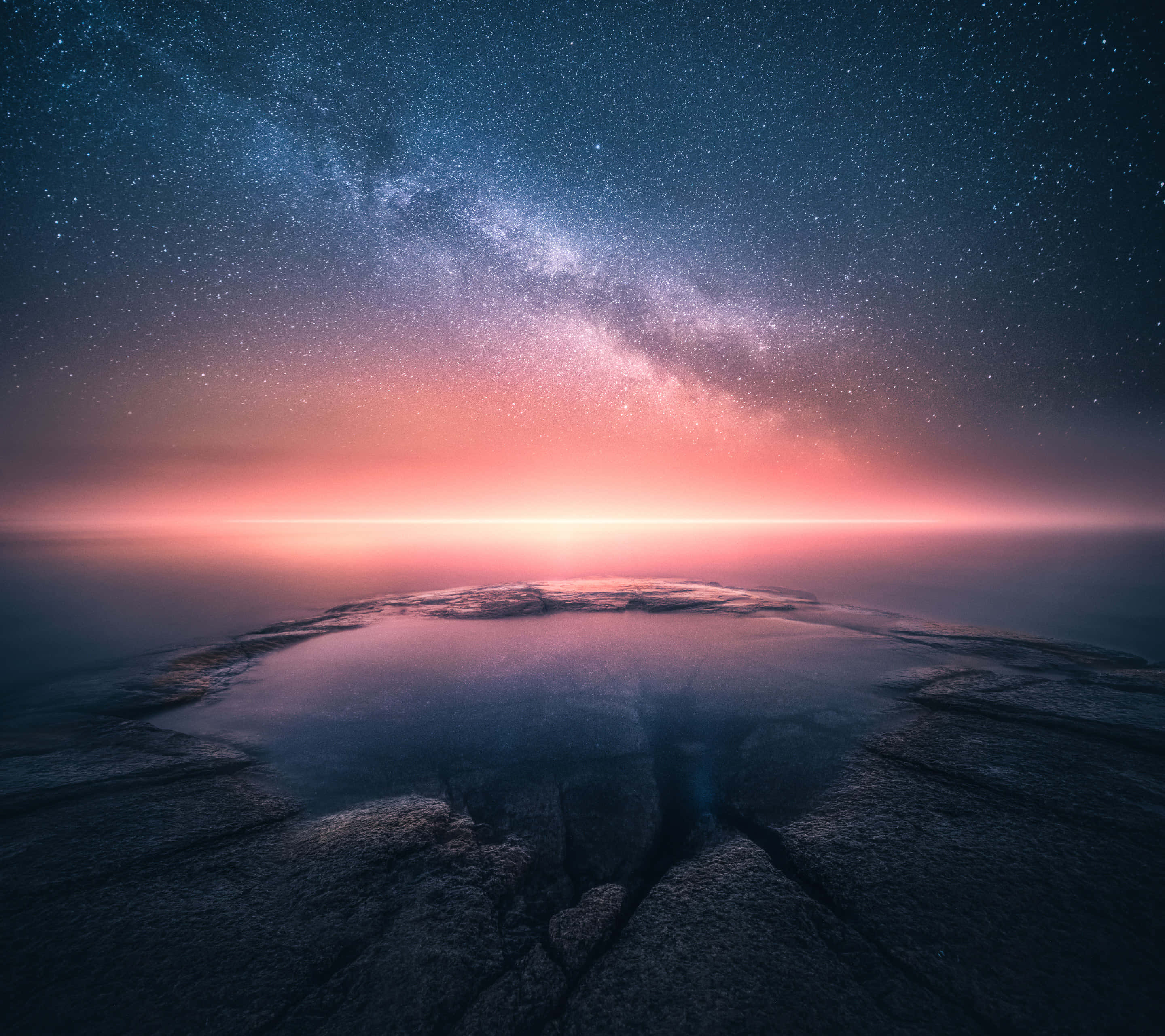 Nokia 桌布 壁紙 — 一個繁星點點的夜空，在岩石表面上的反射池上方有充滿活力的粉紅色地平線。