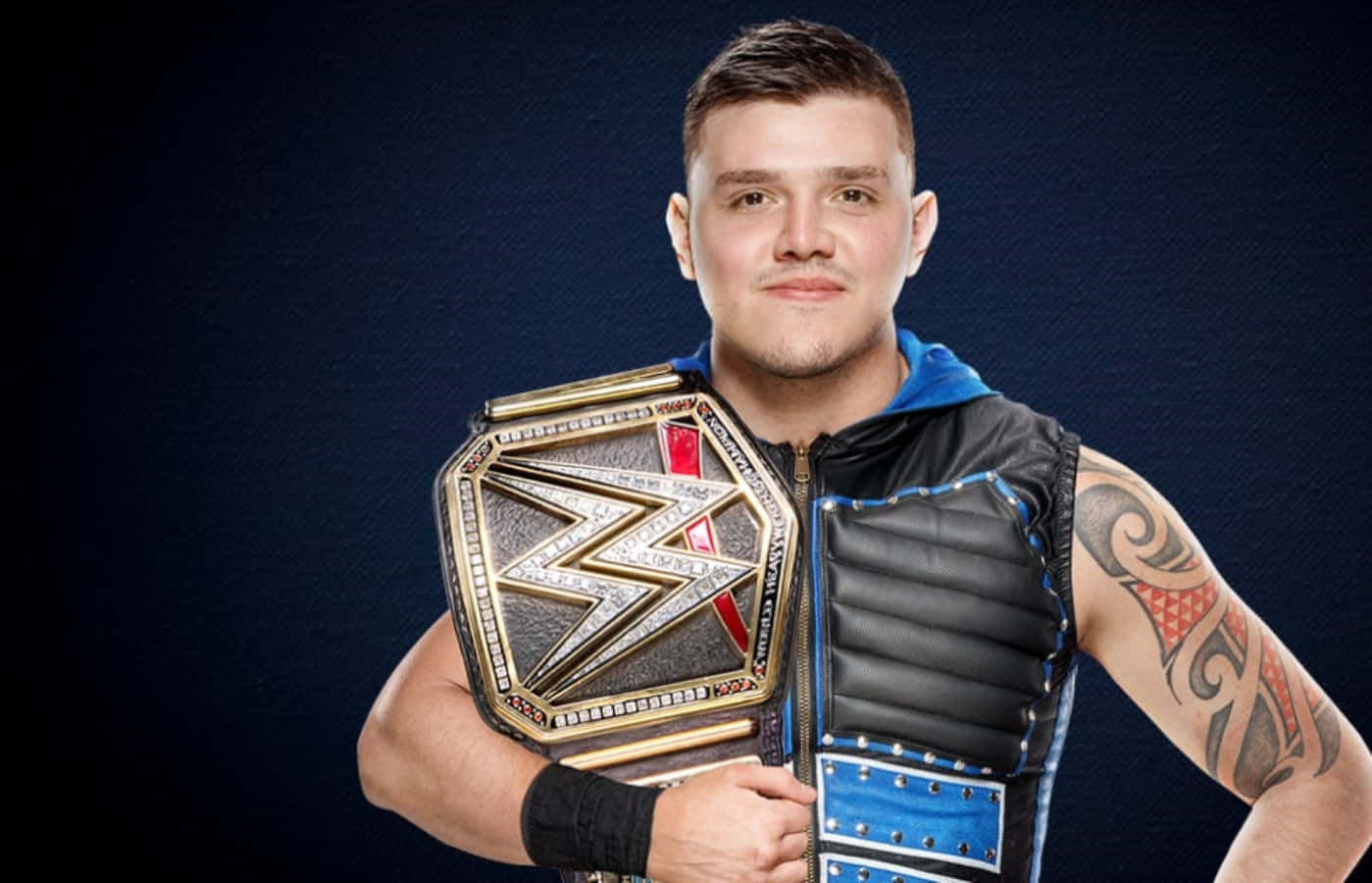 WWE 桌布 壁紙 — 一個肌肉發達、有紋身的摔角手，在深色紋理背景前舉起閃亮的冠軍腰帶。
