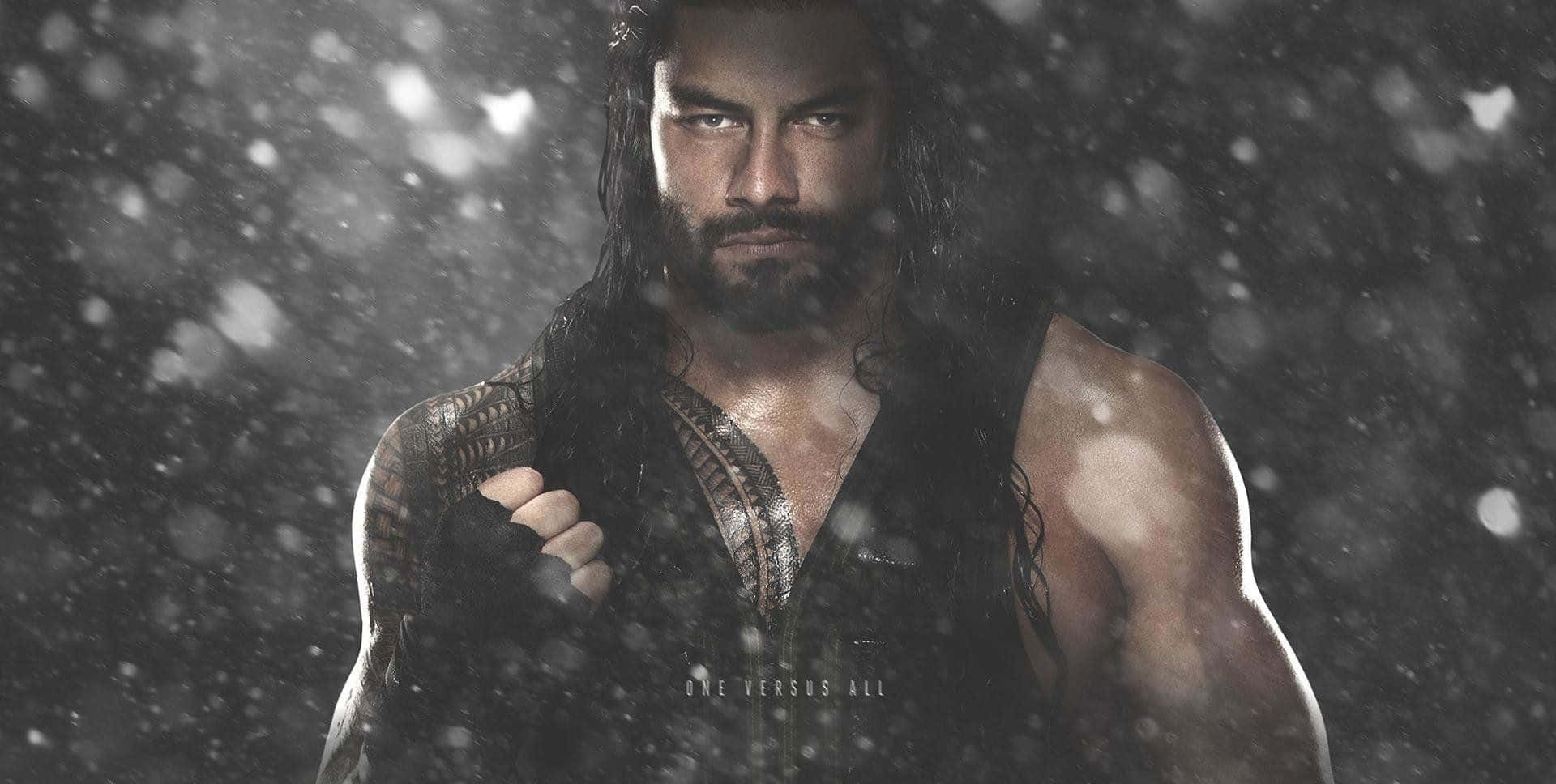 Roman Reigns 桌布 壁紙 — 一個肌肉發達、留著黑色長髮和鬍鬚的男人，在粗糙的黑白場景中，透過飄落的雪花凝視著。