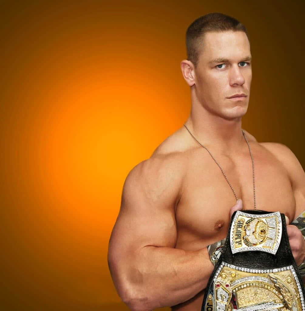 John Cena 桌布 壁紙 — 一個肌肉發達、表情嚴肅的男人，在溫暖的橙色漸變背景前，手持冠軍腰帶。