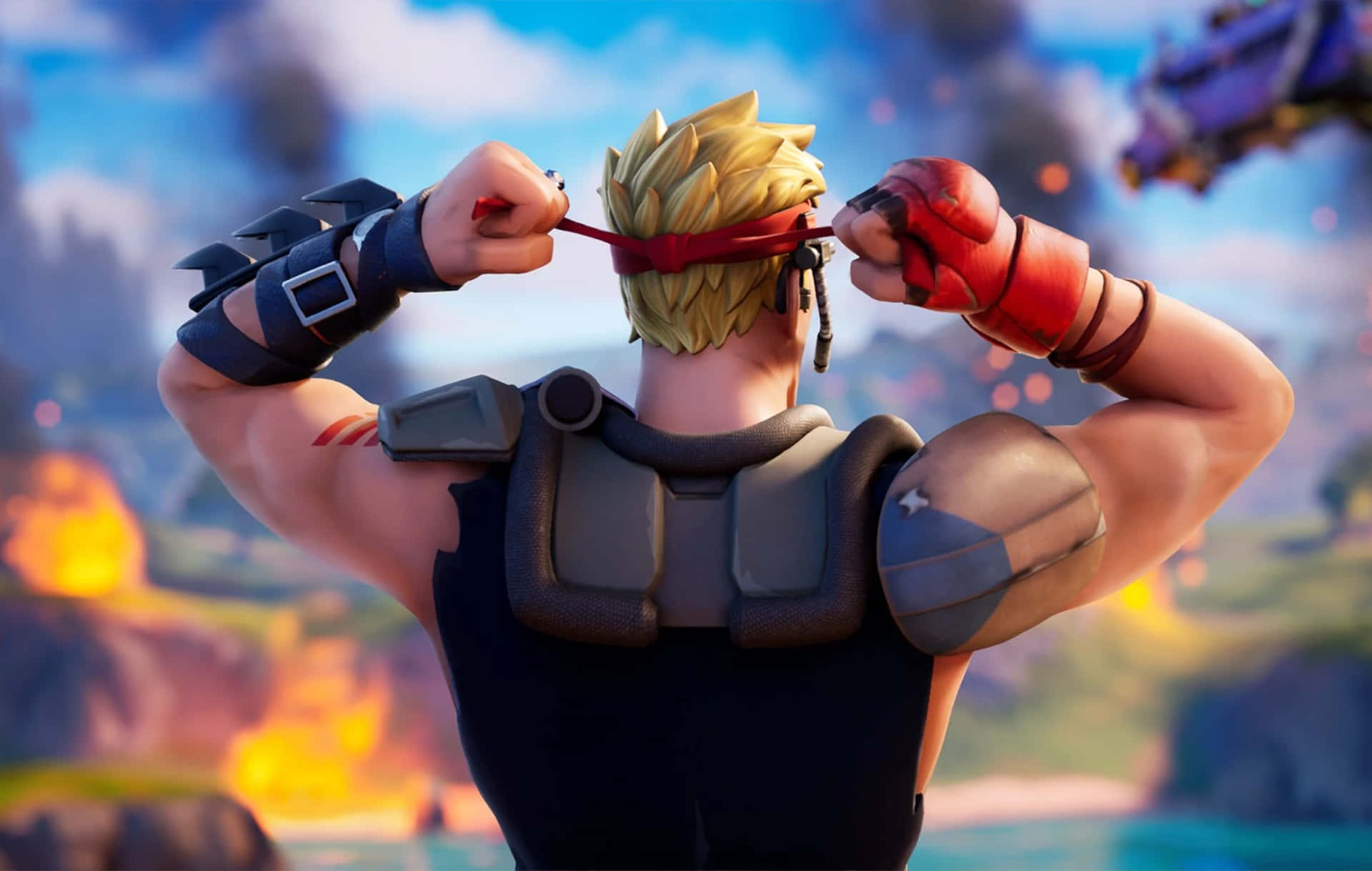 Building Game 桌布 壁紙 — 一個肌肉發達嘅Fortnite角色，留著尖刺金髮，綁住紅色頭帶，面對住熾熱嘅戰場。