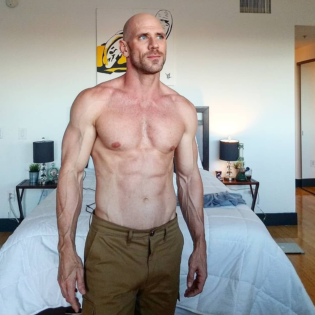 Fitness 桌布 壁紙 — 一個肌肉發達的光頭男人赤膊站在一個有白色床單和黑色燈的現代臥室裡。