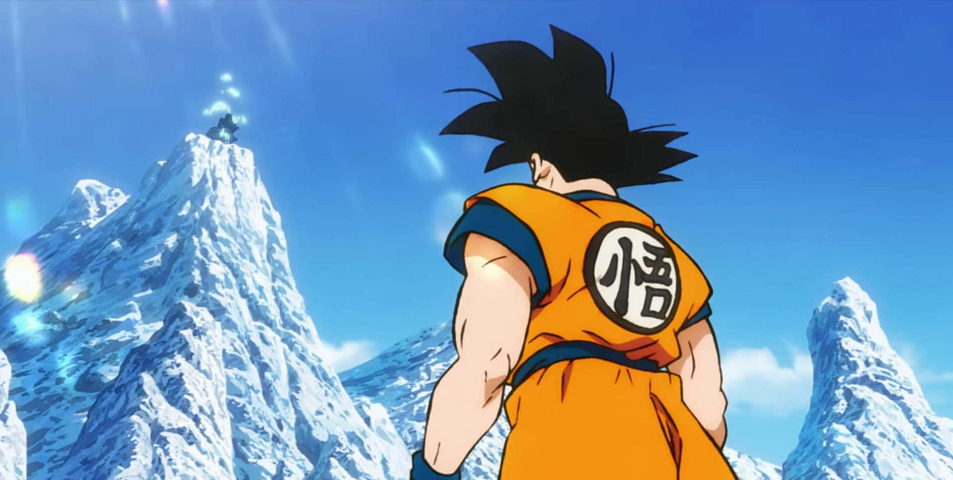 Dragon Ball Movies 桌布 壁紙 — 一個肌肉發達的動漫戰士穿著橙色道服，站在白雪覆蓋的山峰上，凝視著遠處另一個白雪覆蓋的山峰上的人物，天空湛藍明亮。
