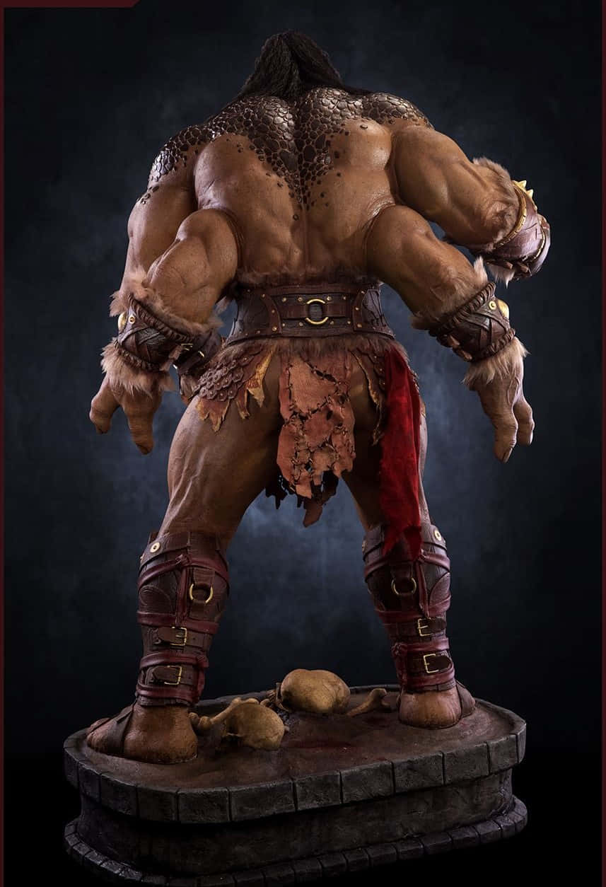 Mortal Kombat Goro 桌布 壁紙 — 一個肌肉發達的奇幻戰士雕像，穿著毛皮盔甲和皮革裝備，在黑暗煙霧背景中背光站立。